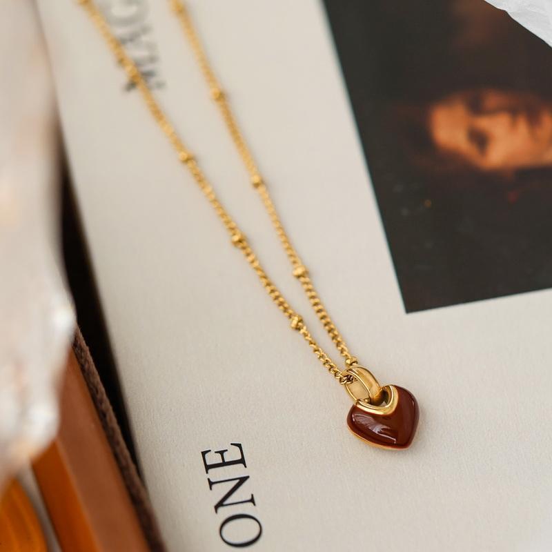 Gold chain necklace with a glossy red enamel heart pendant