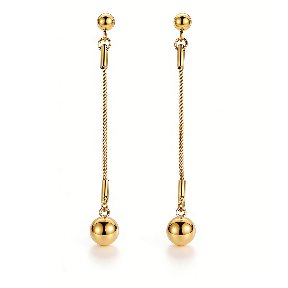 A pair of long gold ball pendant earrings with a stud top, fine chain, and spherical drop
