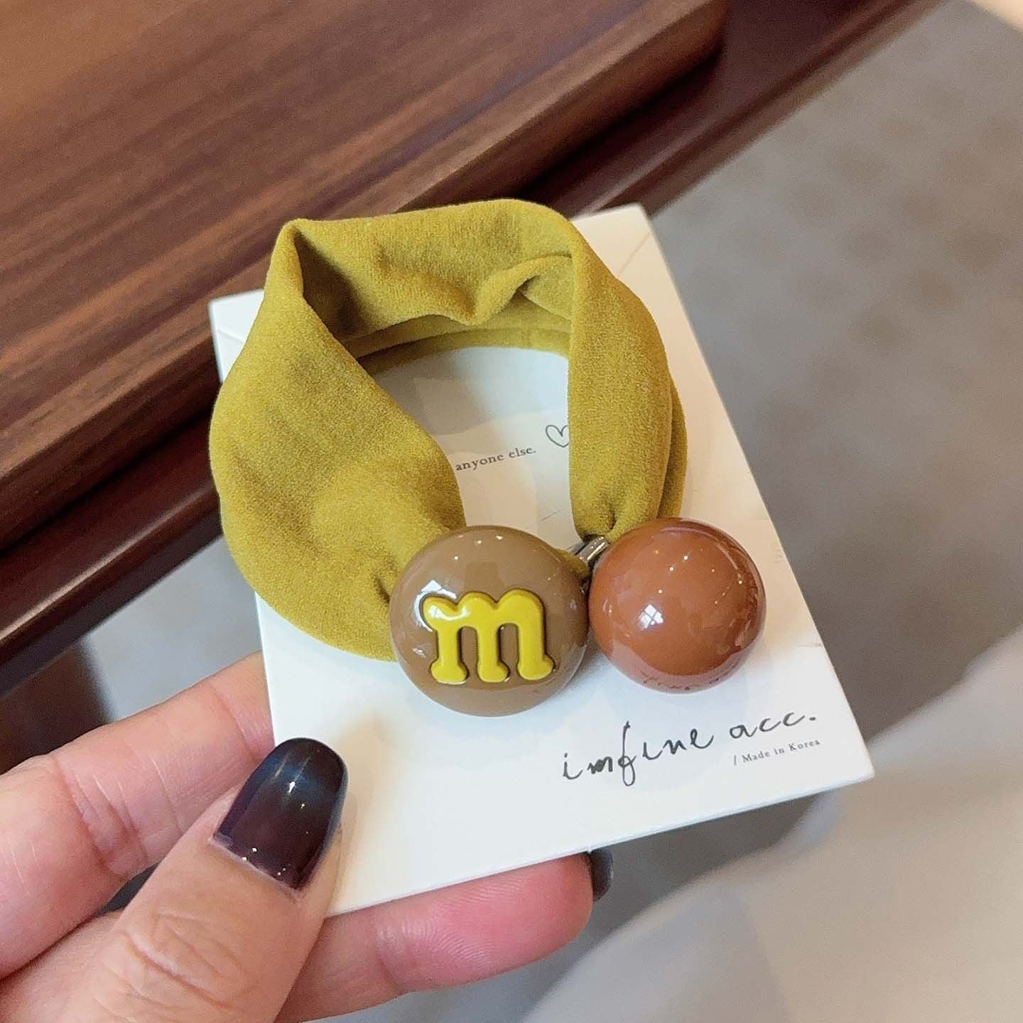 M&M candy bean hair tie with coffee bean charm on a mustard band