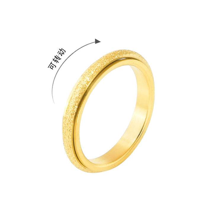 Thin gold ring with a frosted texture and rotating band on a white background