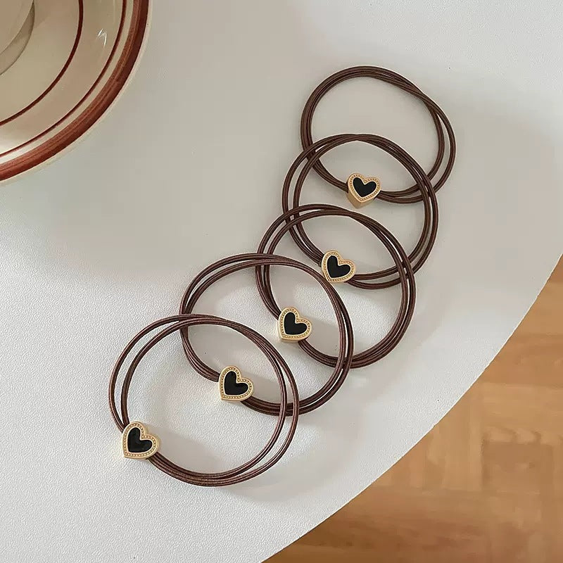Brown cord hair tie with a small gold-tone heart charm