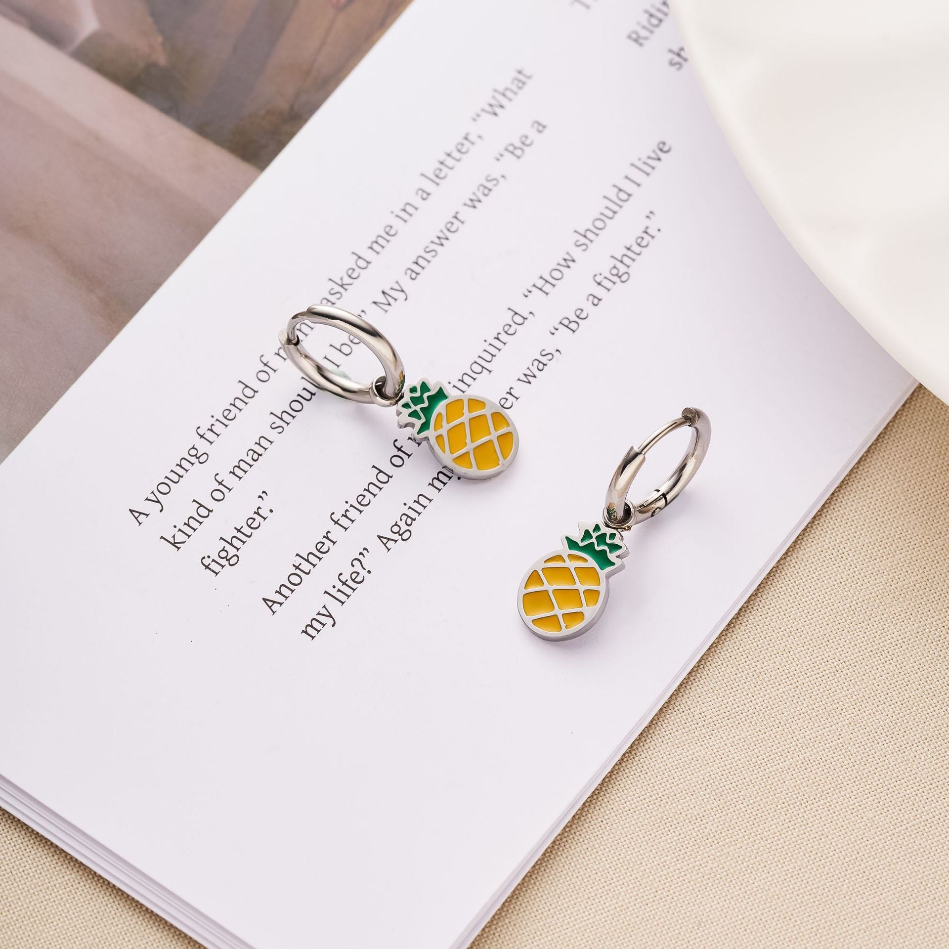 Pair of hoop earrings with enamel pineapple charms in yellow and green