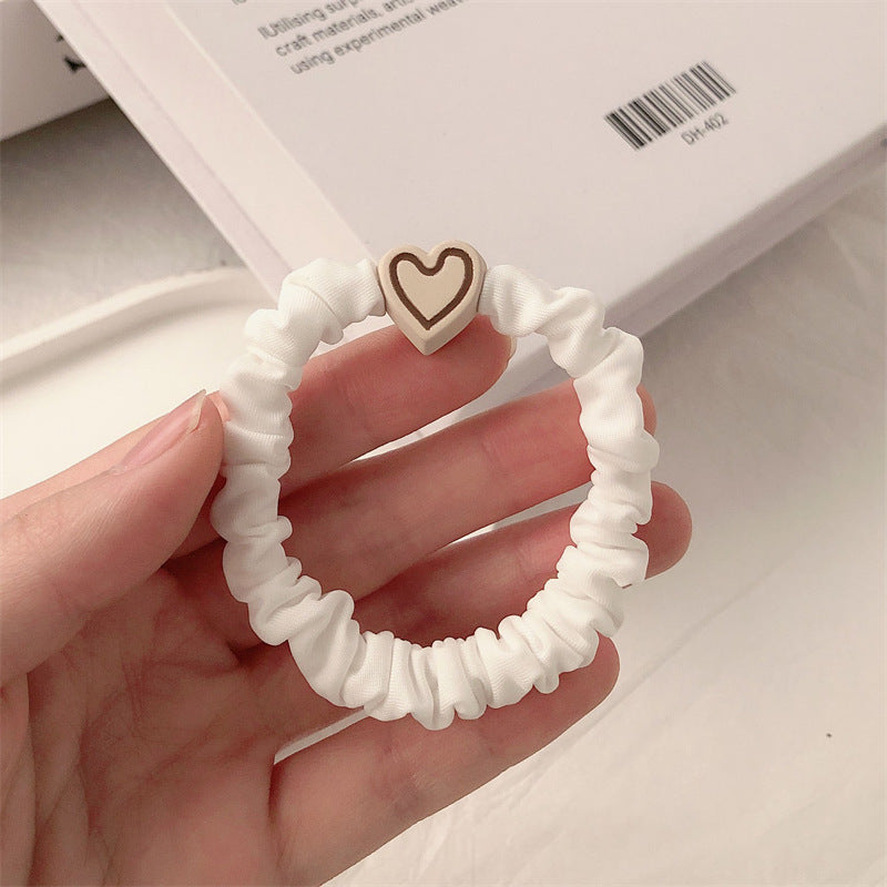 White scrunchie hair tie with a heart charm