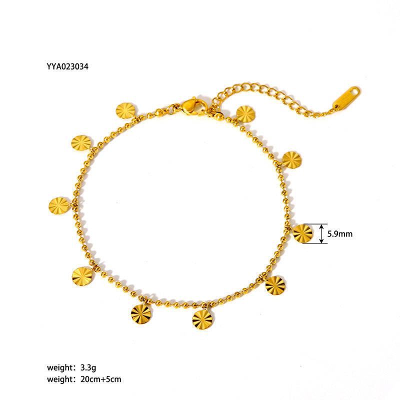 Gold anklet featuring a delicate bead chain and hanging sunburst discs