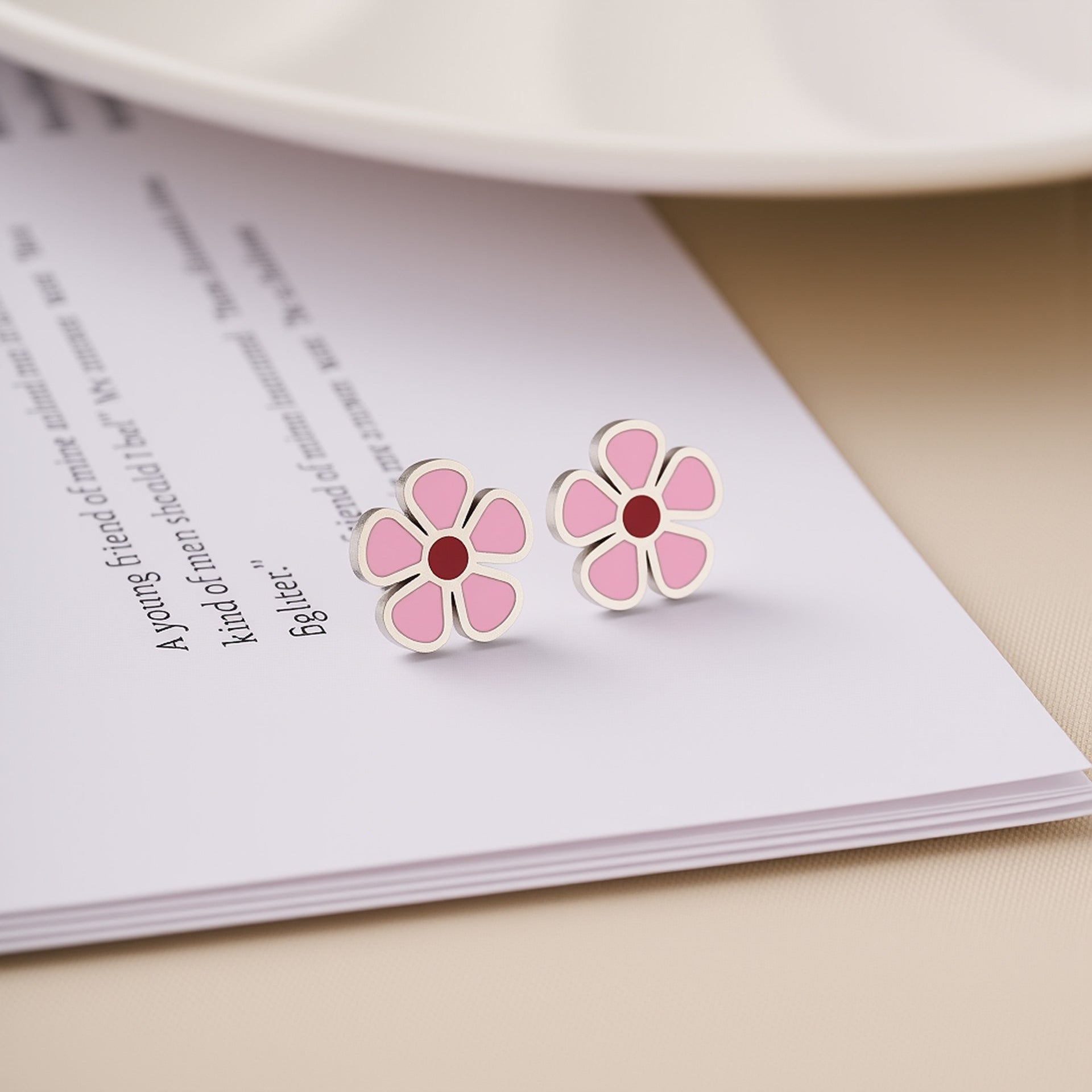 Pink enamel daisy flower stud earrings with dark centers and metallic outlines