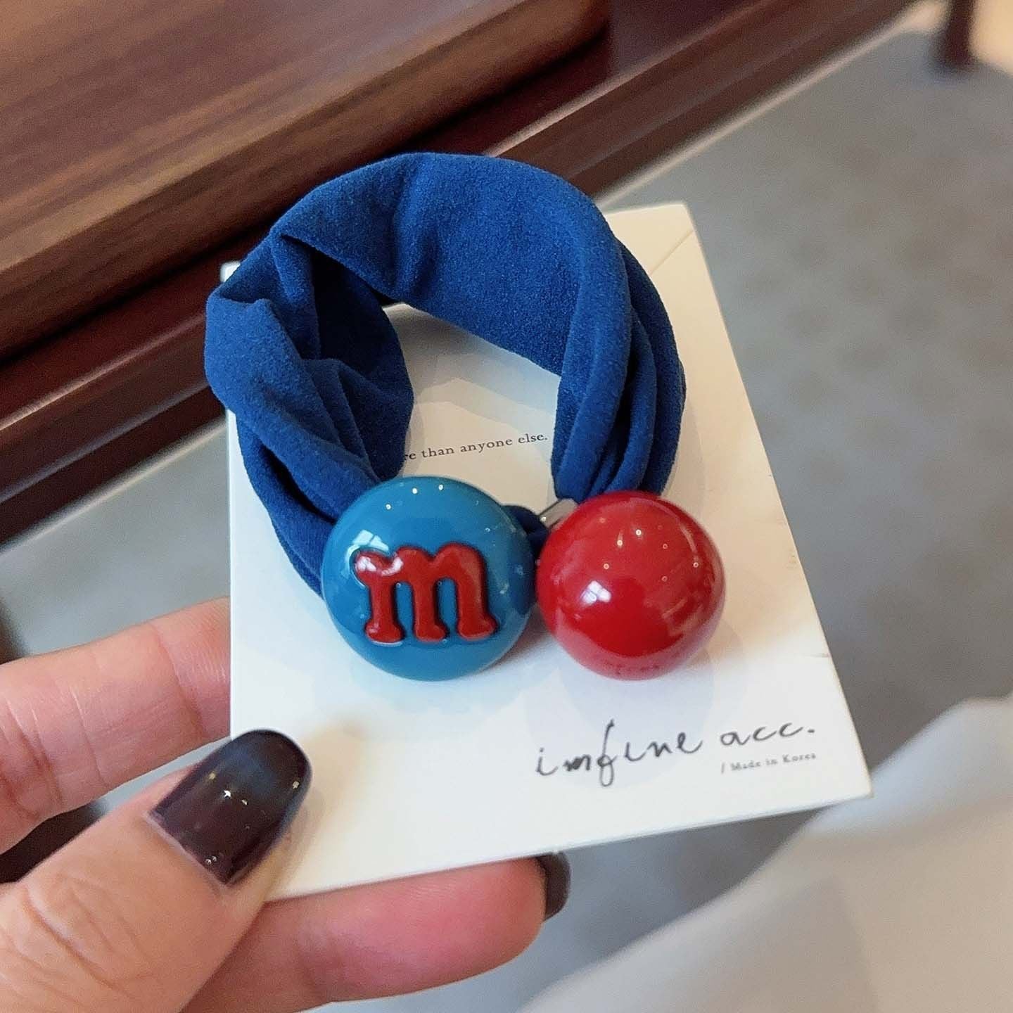 M&M candy bean hair tie with blue bean charm on a blue band