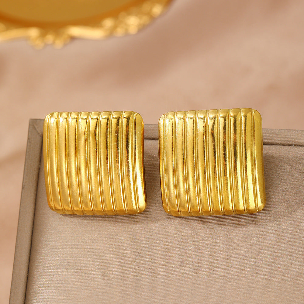 A pair of gold-plated square stud earrings featuring vertical ribbed stripes.