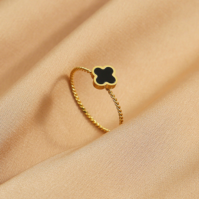 Gold twist ring featuring a black clover motif